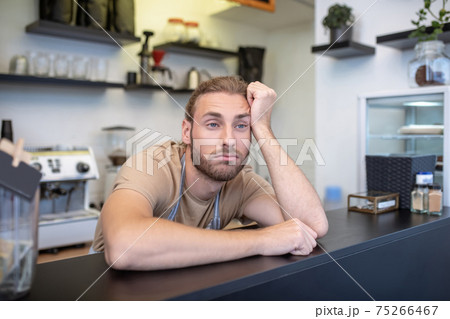 Frustrated young man behind bar in cafe 75266467