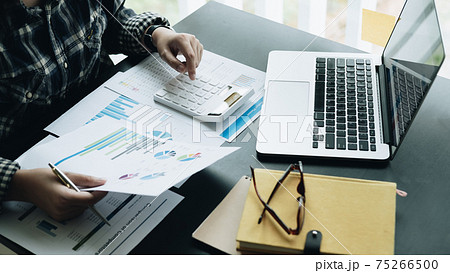 Close up Businessman and partner using calculator and laptop for 75266500