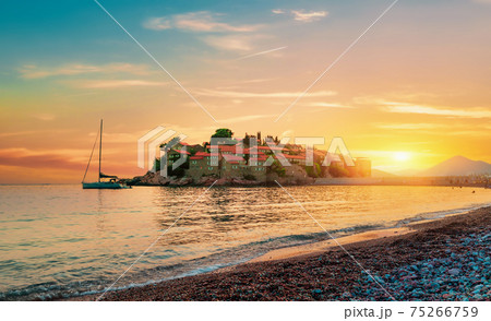 Island in sea at sunset 75266759