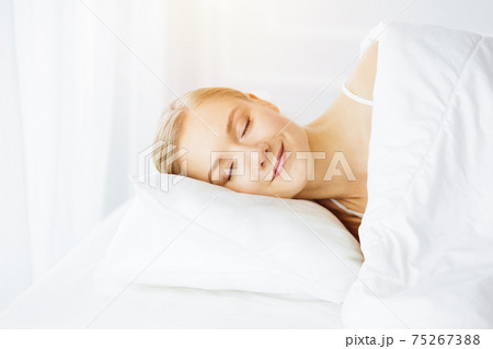 Beautiful young woman sleeping in bedroom comfortably and blissfully Beautiful young woman sleeping in bedroom comfortably and blissfully 75267388