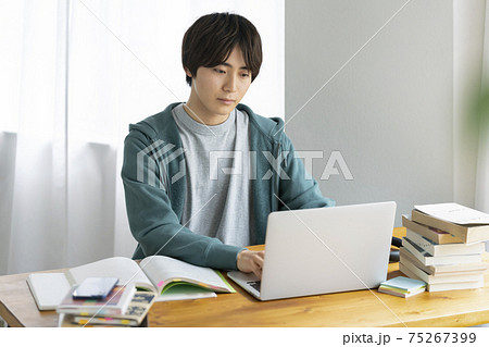 パソコンに向かって勉強する若い男性 オンライン授業を受ける学生 イメージ パソコンに向かって勉強する若い男性 オンライン授業を受ける学生 イメージ 75267399