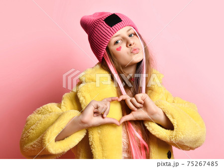 Bright teen girl showing heart to camera while 75267485