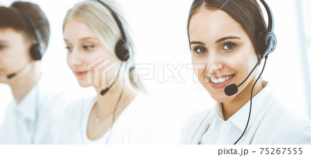 Call center. Group of diverse operators at work. Beautiful woman in headset communicating with customers of telemarketing service. Business concept Call center. Group of diverse operators at work. Beautiful woman in headset communicating with customers of telemarketing service. Business concept 75267555