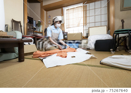 散らかった部屋を片付ける女性作業員 75267640