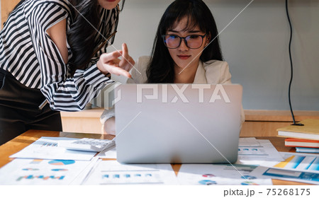 Business professionals. Group of young confident business people analyzing data using computer in the office. 75268175