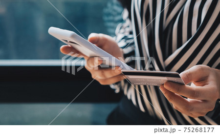 Online payment,Woman's hands holding a credit card and using smart phone for online shopping. Online payment,Woman's hands holding a credit card and using smart phone for online shopping. 75268177