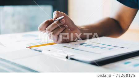 Close up accountant hand holding pen working on business finance data, accountancy document and laptop computer at office, business concept. Close up accountant hand holding pen working on business finance data, accountancy document and laptop computer at office, business concept. 75268178