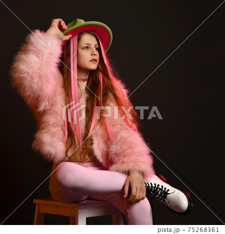 Teenager girl posing in studio wit a chair and a 75268361