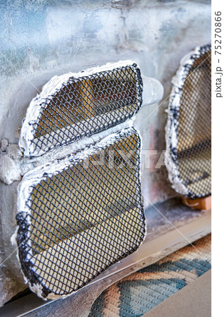 Metal grid installed on bumper with sealer at car tuning station Metal grid installed on bumper with sealer at car tuning station 75270866