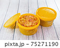 Frozen cloudberries in yellow plastic containers 75271190