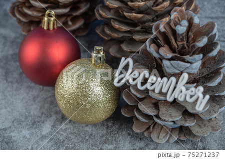 Christmas tree cone with december writing on it and glittering figures around Christmas tree cone with december writing on it and glittering figures around 75271237