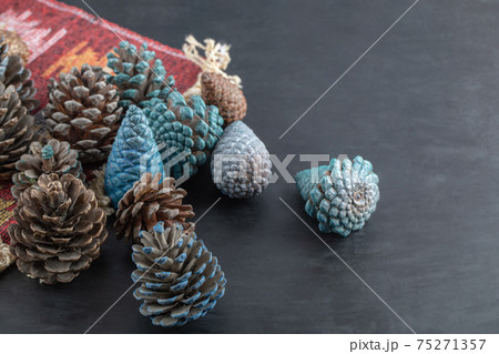 Colorful oak tree cones on a piece of red pattern ethnic rug 75271357