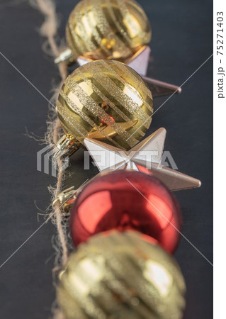 Colorful ornaments hanged from the rustic thread on the dark stone background Colorful ornaments hanged from the rustic thread on the dark stone background 75271403