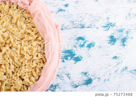 Dry macaroni inside pink cloth on colorful background 75271488