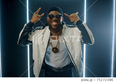 Smiling rapper on the stage with illuminated cube 75272386