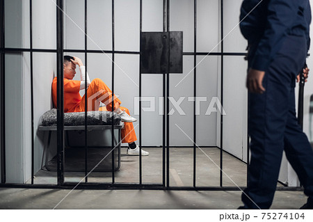 A male warden guards cells with dangerous criminals in a high-security prison. Dangerous profession. 75274104