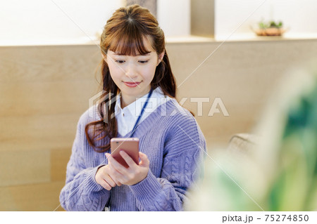 カフェでスマホを使って話をするビジネスウーマン 75274850