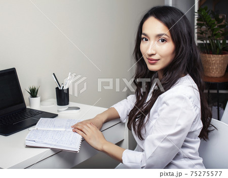 young pretty asian woman in white form working in clinic with laptop, lifestyle working people concept 75275577