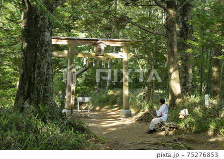 石鎚山遥拝の鳥居で休憩する信者の男性（愛媛県） 75276853