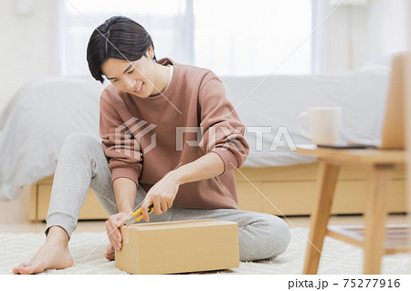 ダンボールを開ける男性 通販 75277916