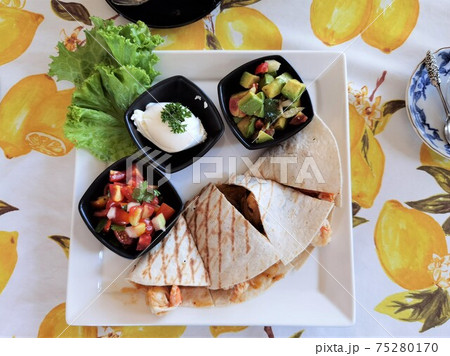 shrimp quesadilla with dressing on the plate 75280170