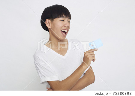 Asian man showing credit card Asian man showing credit card 75280398