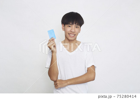 Asian man showing credit card 75280414