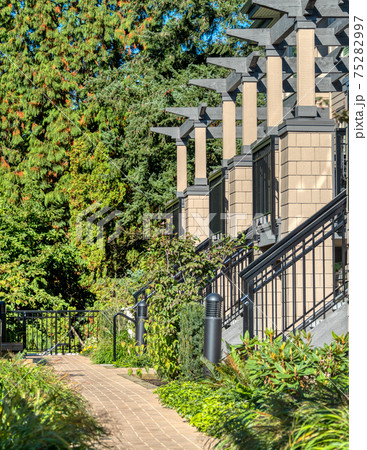 Porches of residential townhouses in a row with paved pathway in front Porches of residential townhouses in a row with paved pathway in front 75282997