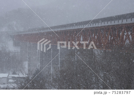 豪雪に霞む札幌自動車道の鉄橋（北海道） 75283797