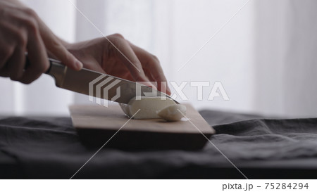 man slicing mozzarella ball on olive wood board with window on background man slicing mozzarella ball on olive wood board with window on background 75284294