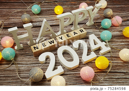 Happy New Year 2024 alphabet letter with LED cotton balls on wooden background 75284598