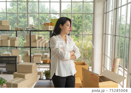 Asian business woman with postal parcel packaging carton box delivery, working from home, selling products online business. Shipping service. People lifestyle in coronavirus pandemic. SME ecommerce Asian business woman with postal parcel packaging carton box delivery, working from home, selling products online business. Shipping service. People lifestyle in coronavirus pandemic. SME ecommerce 75285008