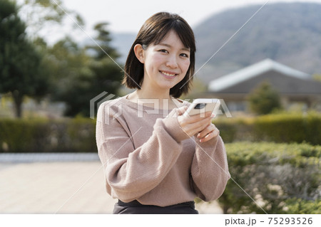 公園でスマートフォンを使う女性 公園でスマートフォンを使う女性 75293526