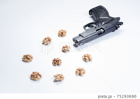 Pistol and walnuts. Pistol and peeled nuts. Isolate 75293690