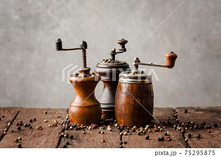 Vintage wooden pepper mills with peppercorns Vintage wooden pepper mills with peppercorns 75295875
