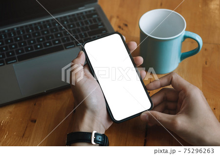 Mockup image blank white screen cell phone.men hand holding texting using mobile relax on sofa at home. background empty space for advertise text.people contact marketing business and technology. 75296263