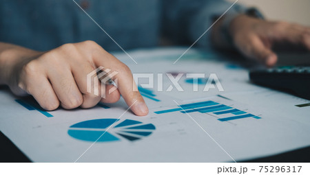 Close up businessman or accountant working using calculator with financial report and calculator. Close up businessman or accountant working using calculator with financial report and calculator. 75296317