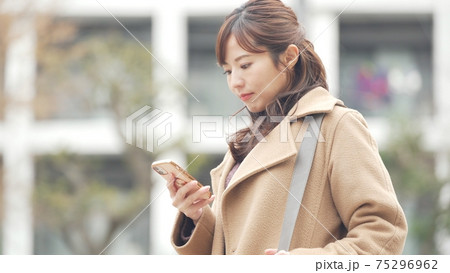 スマホを操作すコート姿の女性 スマホを操作すコート姿の女性 75296962