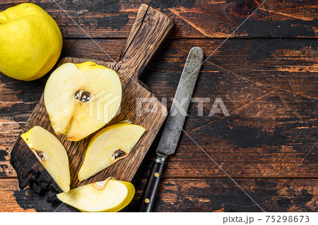 Fresh gold quince fruits on a cutting board. Dark wooden background. Top view. Copy space Fresh gold quince fruits on a cutting board. Dark wooden background. Top view. Copy space 75298673