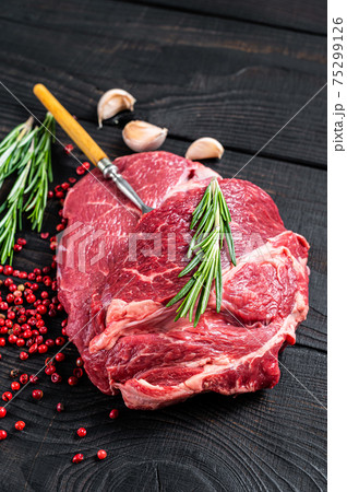Fresh Raw Chuck eye roll beef steak on butcher table. Black wooden background. Top view Fresh Raw Chuck eye roll beef steak on butcher table. Black wooden background. Top view 75299126
