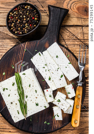 Cut cheese feta with rosemary on a wooden cutting board. wooden background. Top view 75299145