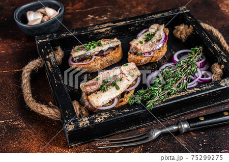 Tapas with sardine and sprat, cream cheese and onion. Dark background. Top view Tapas with sardine and sprat, cream cheese and onion. Dark background. Top view 75299275
