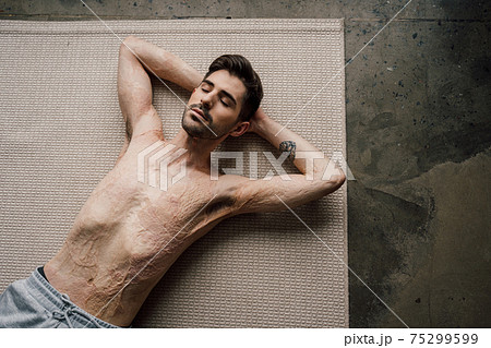 Man laying at the floor after swinging press at the living room Man laying at the floor after swinging press at the living room 75299599