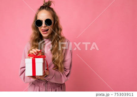 Shot of beautiful surprised positive young blonde curly woman isolated over pink background wall 75303911