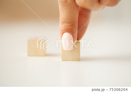 Woman hand putting and stacking blank wooden cubes on desk with copy space for input wording and infographic icon. 75306204