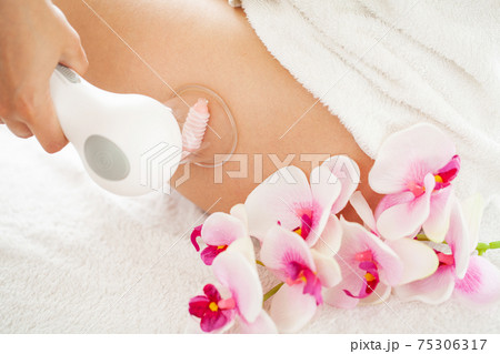 Woman getting LPG massage for skin care in home 75306317