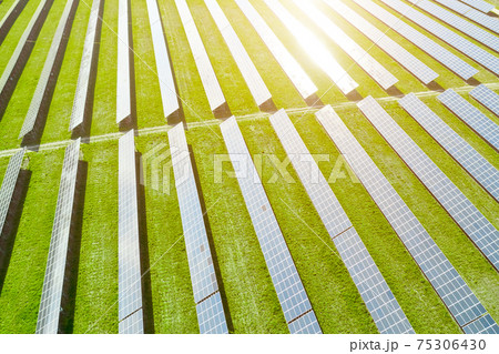 Aerial view of solar power station. Photovoltaic panels field for production of renewable energy. Reflection of sunlight in the panels.  75306430