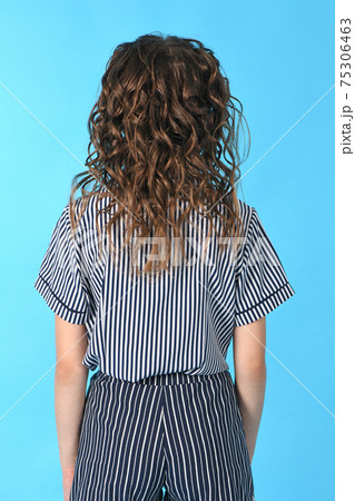 Rear view of girl with curly hair. Isolated on blue background. Rear view of girl with curly hair. Isolated on blue background. 75306463