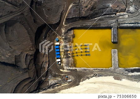 Top view on a pool with yellow liquid used in a coal mining in a quarry. Heavy industry concept Top view on a pool with yellow liquid used in a coal mining in a quarry. Heavy industry concept 75306650