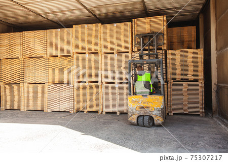 The old forklift load lumber into dry warehouse 75307217
